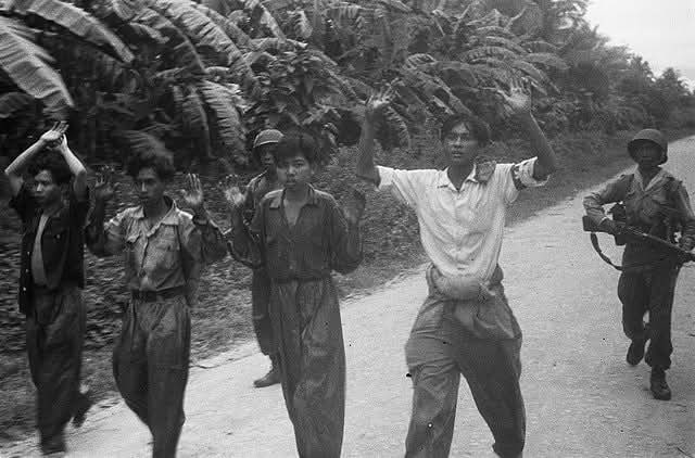 Potret empat pejuang kemerdekaan Indonesia dengan tangan terangkat di giring dua tentara KNIL Belanda di wilayah Tapanuli-Padang, sekitar Desember 1948
